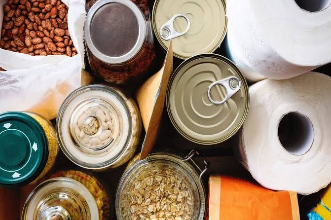 Two weeks of shelf stable food laid out and counted: canned goods, oats, dried beans and paper goods